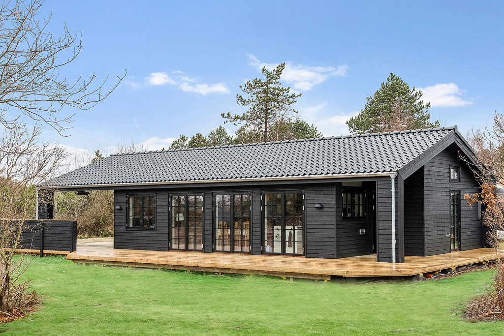 Stenhøj Husene designlinje Black Line. Udefra af det smukke sommerhus med sprossede vinduer og døre i sort.