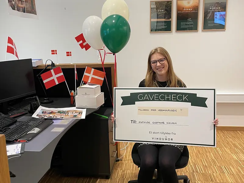 Mathilde som er blevet færdig som elev. Hun sidder med et gavekort.