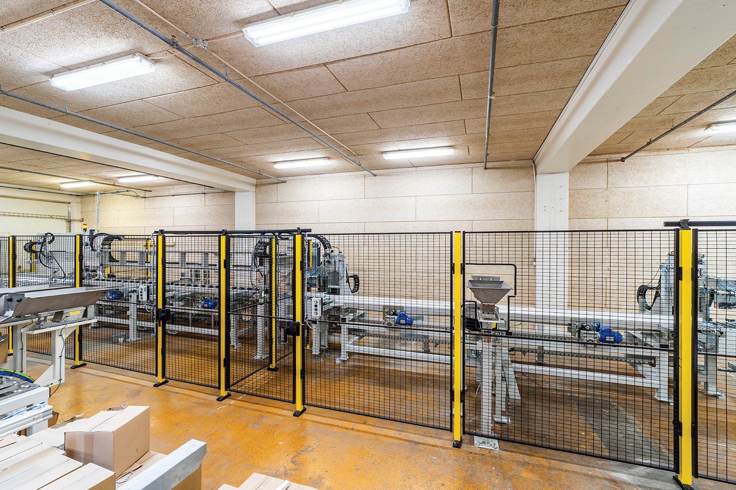 Limdyvel overbliksbillede, hvor man bag et gitter kan se båndet hvor pindene kører.