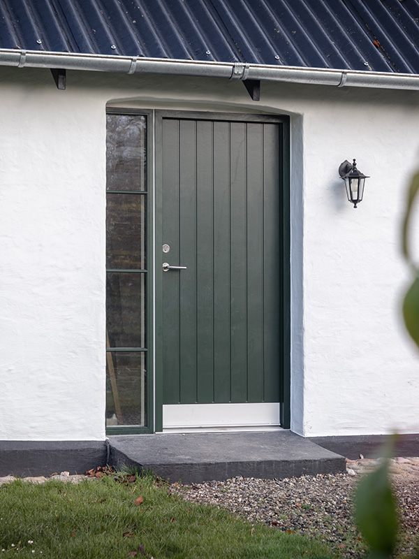 Malet Høng RAL 6009 finér pladedør og alubeklædt karm, samt en fastkarm Nor48 kitfals med 19 mm sprosser.