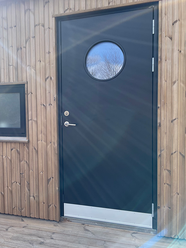 Pladedør i sort RAL 9005 med alu sparkeplade og standard greb.