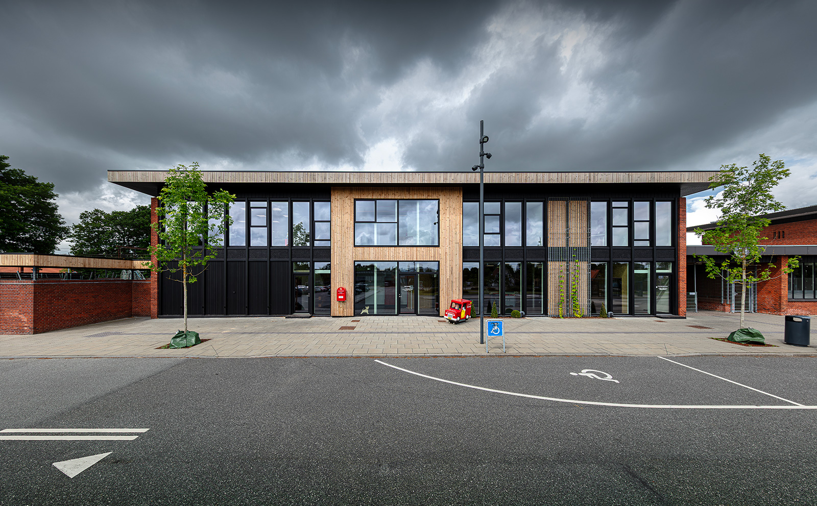 Hovedfacade med træbeklædning, tegl og sorte Nor48 træ/alu vinduer