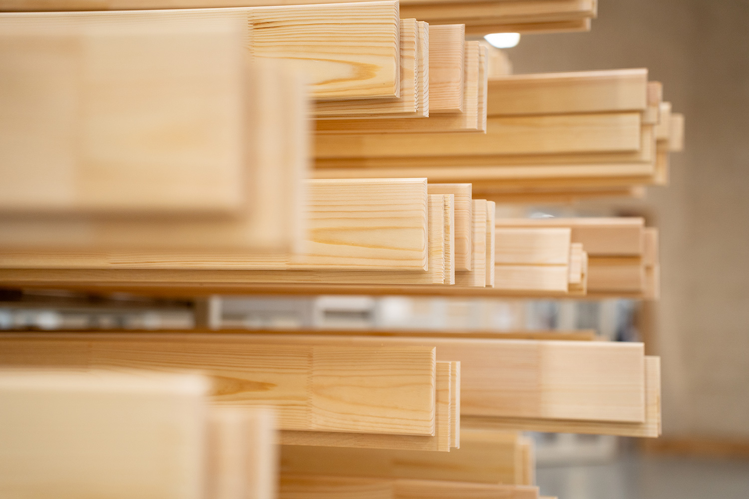 Fyrretræspinde der er afkortet og har været gennem CNC, som ligger på hylder.