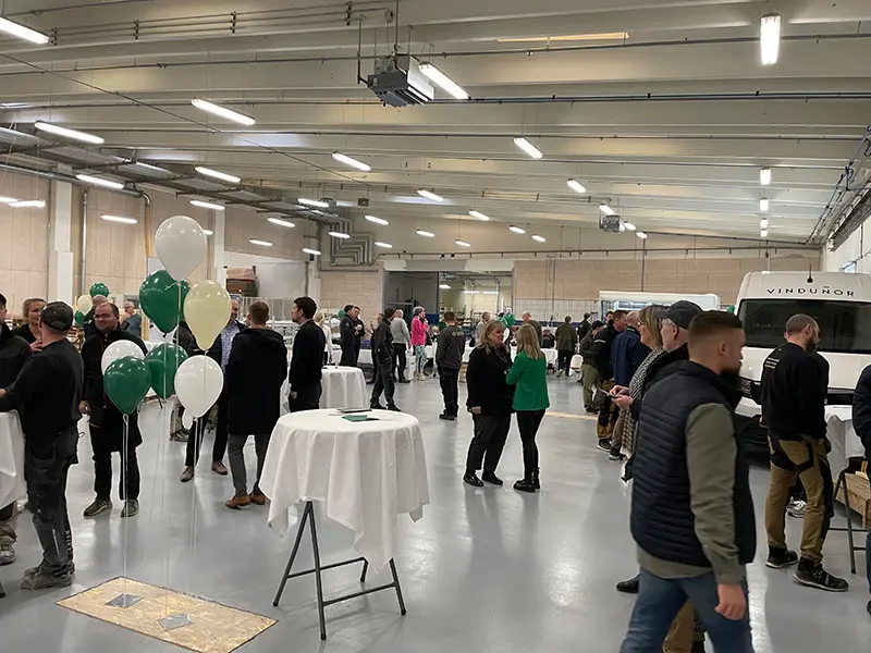 Åben Fabrik 2023 - Gæster står i området for at se servicebil og snakke med hinanden.