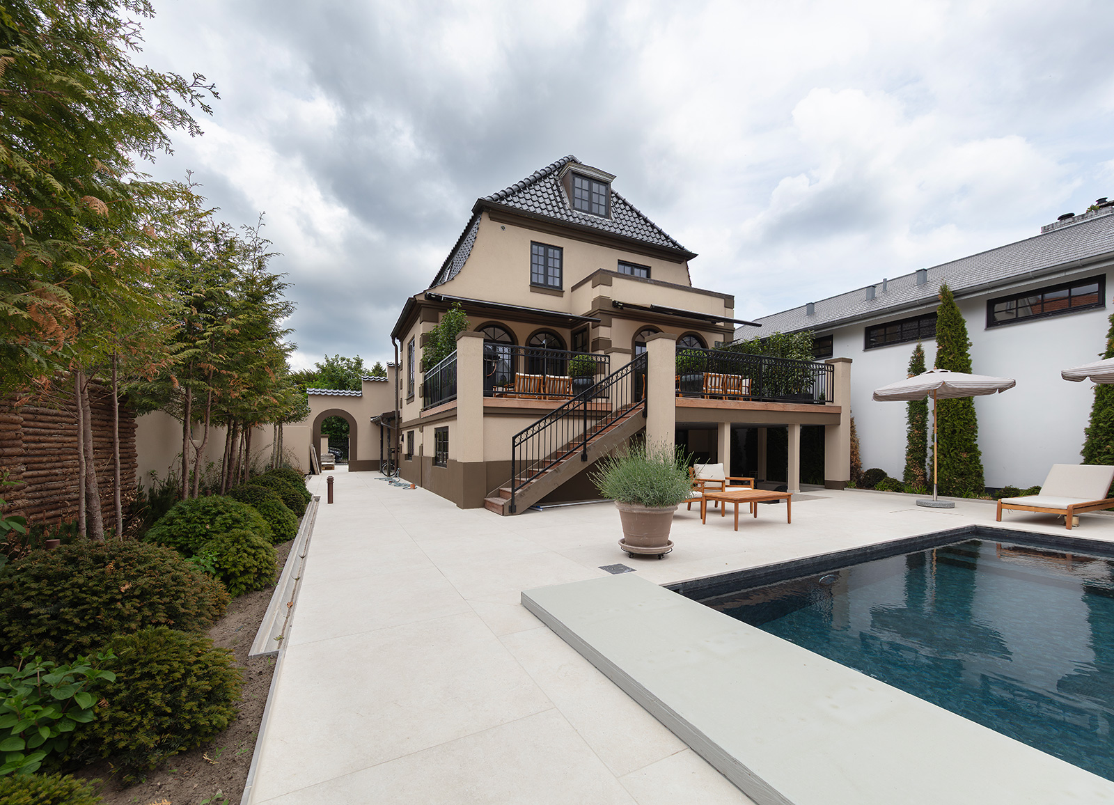 Renoveret villa med elegante Vindunor Nor48 kitfals træ/alu vinduer mod terrasse og poolområde.