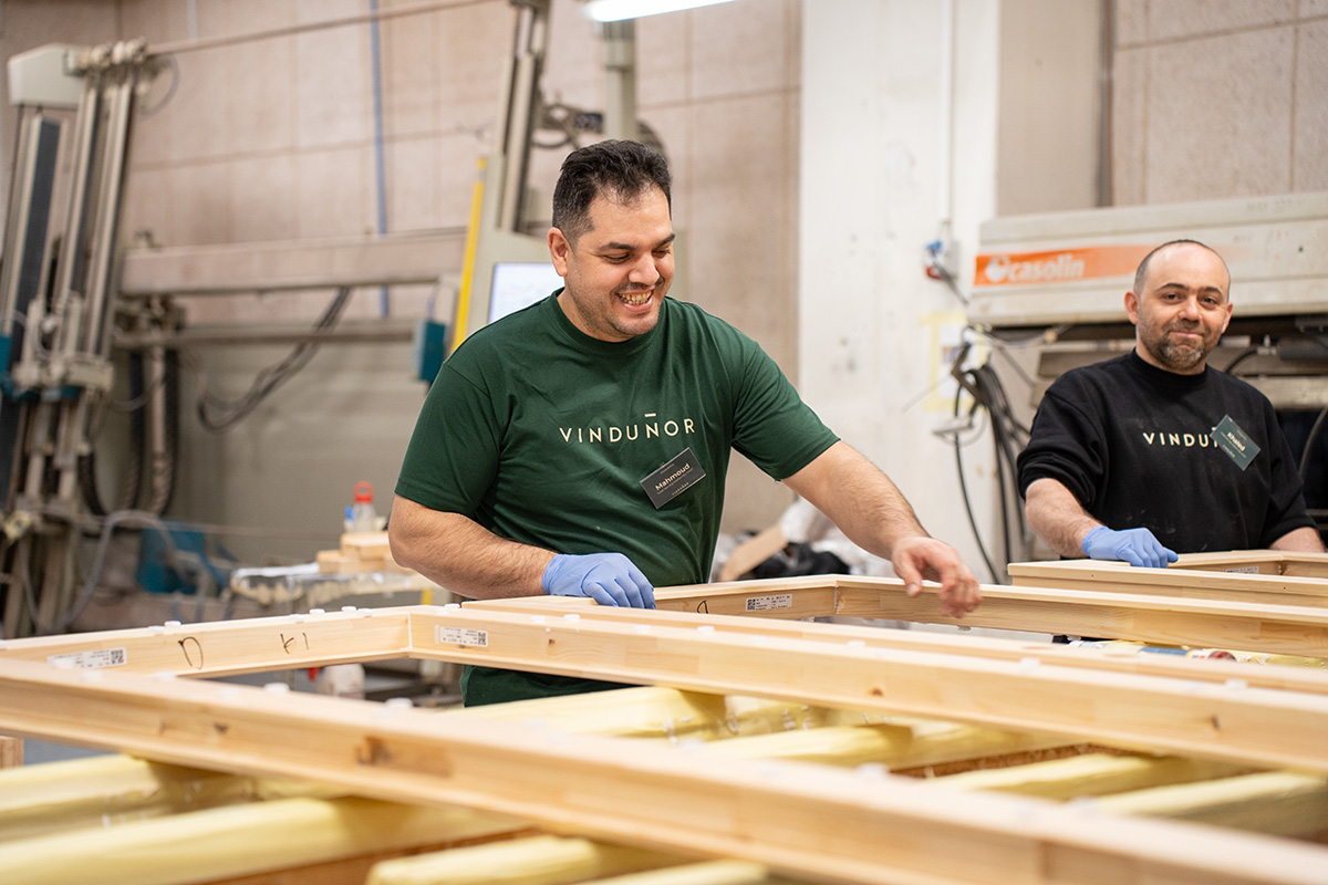 To glade kollegaer fra pressen, som står med et vindueselement.