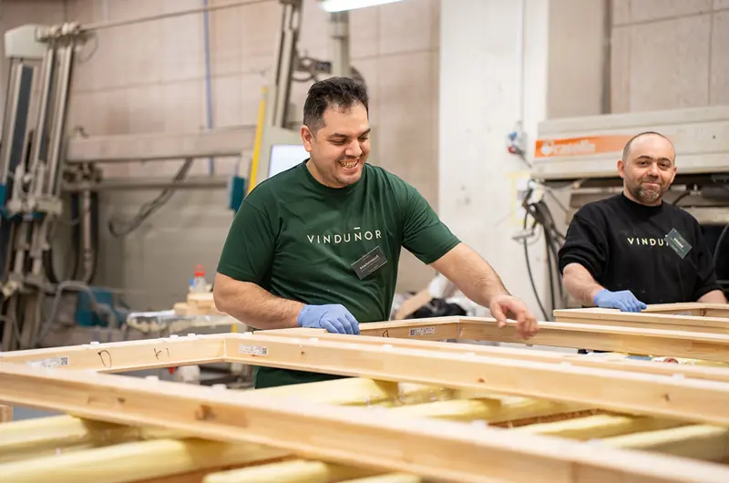 To glade kollegaer fra pressen, som står med et vindueselement.