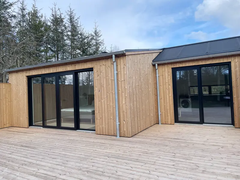 en terrasse med to skydedør en enkelt rettet skydedør og en dobbelt skydedør begge er i sort