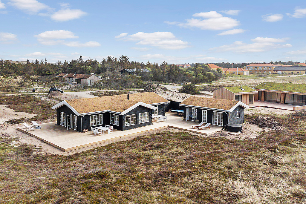 Stenhøj Husene designlinje Lux V. Udvendig af det vanvittige smukke sommerhus med store sprossede vinduer og døre i hvid.