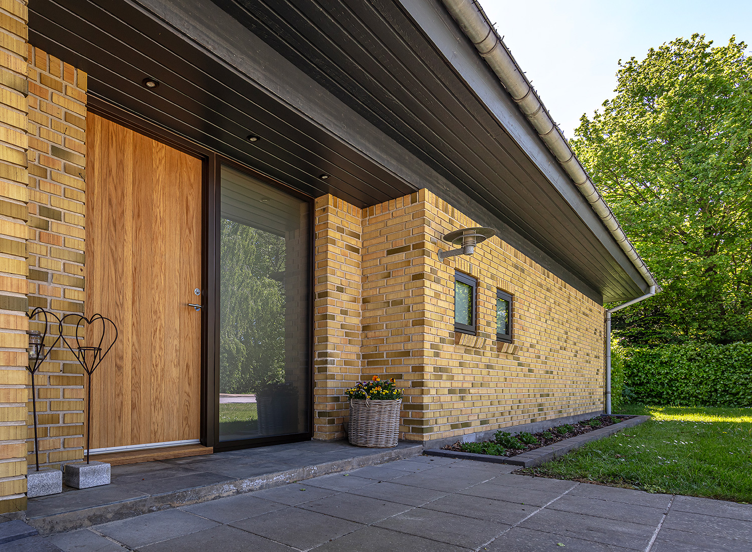 Facaden på en villa med en facadedør lavet i egetræ