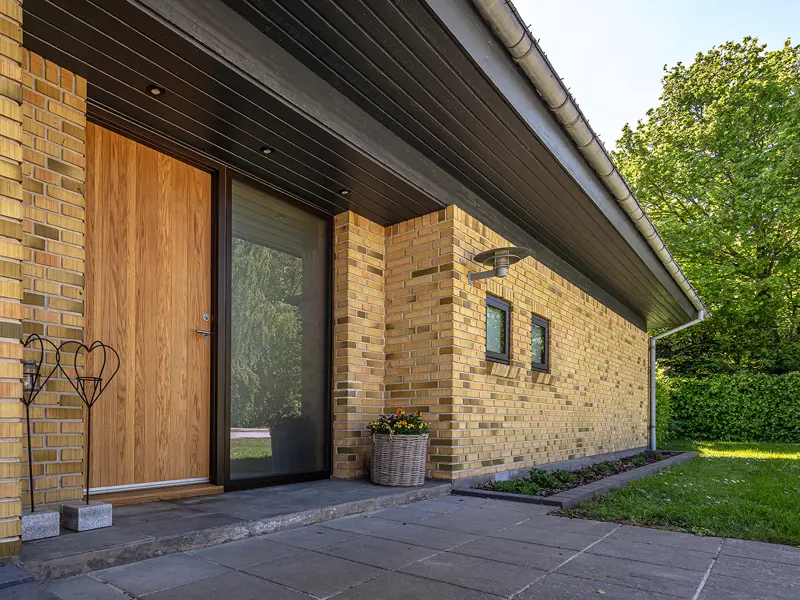 Facaden på en villa med en facadedør lavet i egetræ