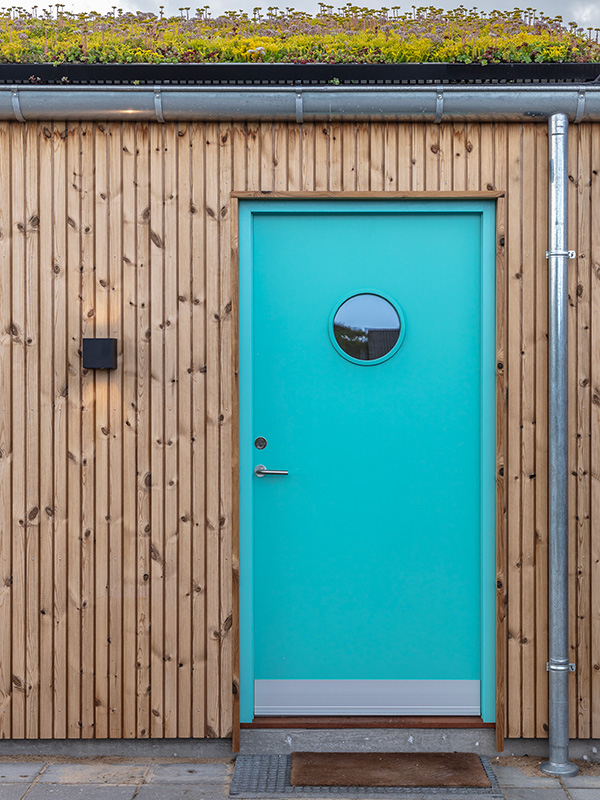 Pladedør i lysegrøn RAL 6027 med mahogni dørtrin og standard greb.