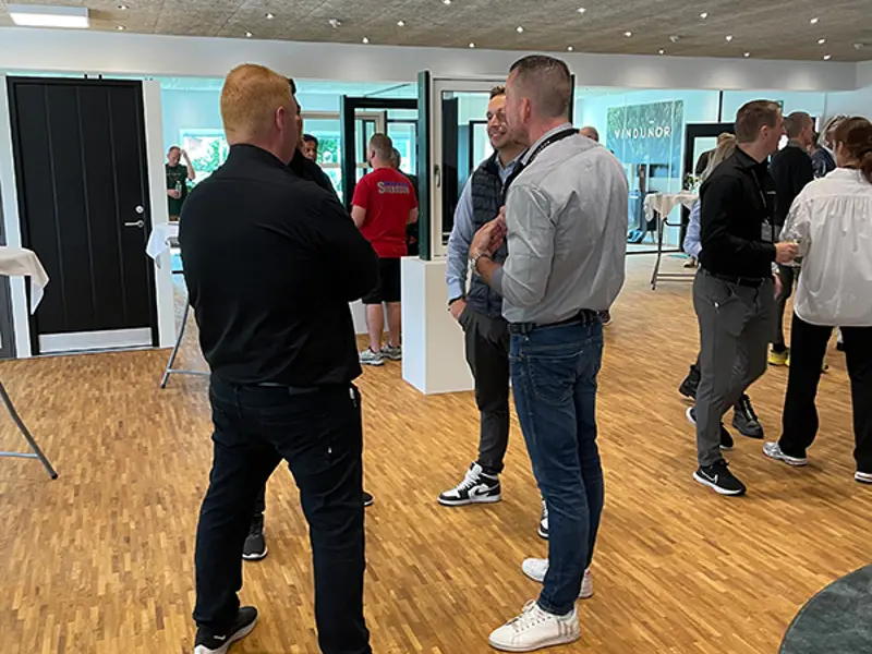 Fire mænd snakker sammen midt i udstillingen til receptionen.