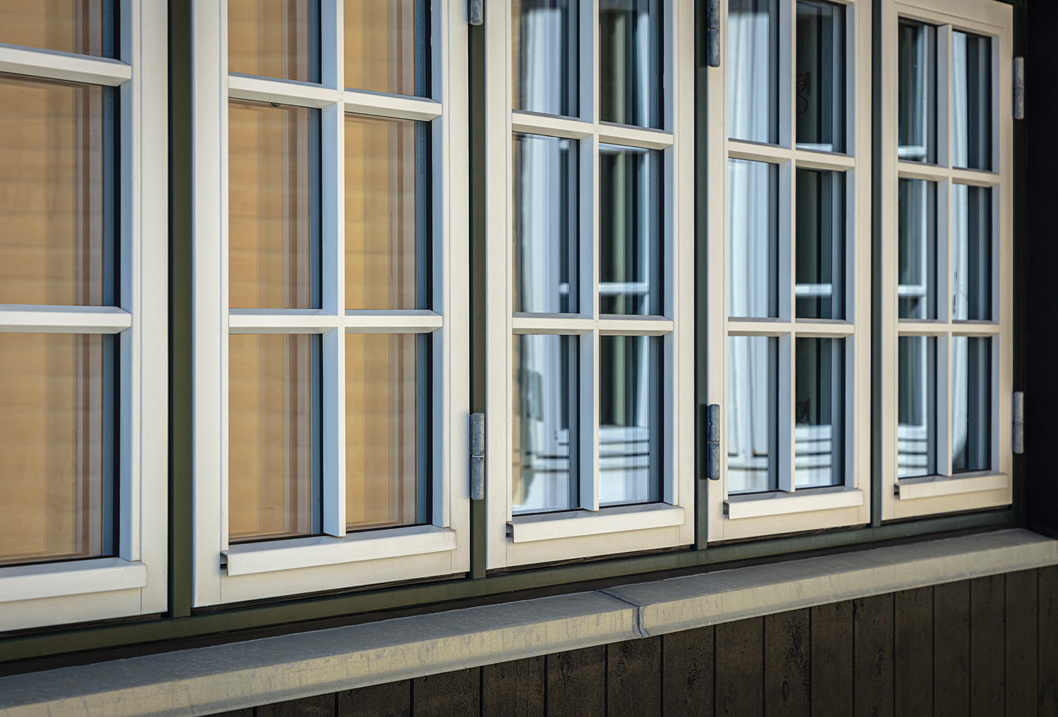 Nærbilledet siden af huset med vinduespartier med bondehus sprosser i farven hvid 