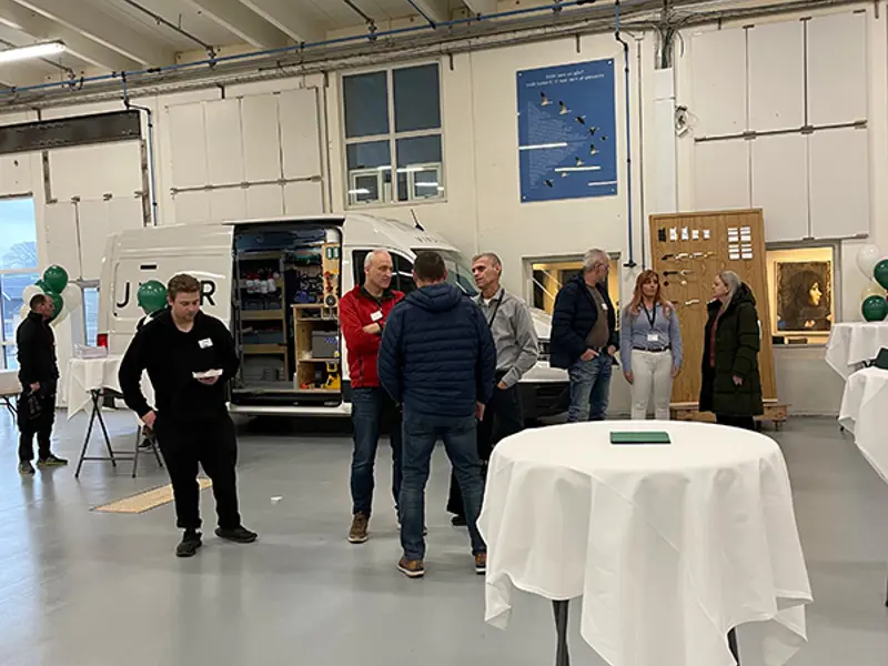 Åben Fabrik 2023 - Gæster ved servicebilen og væggen med tilbehør.