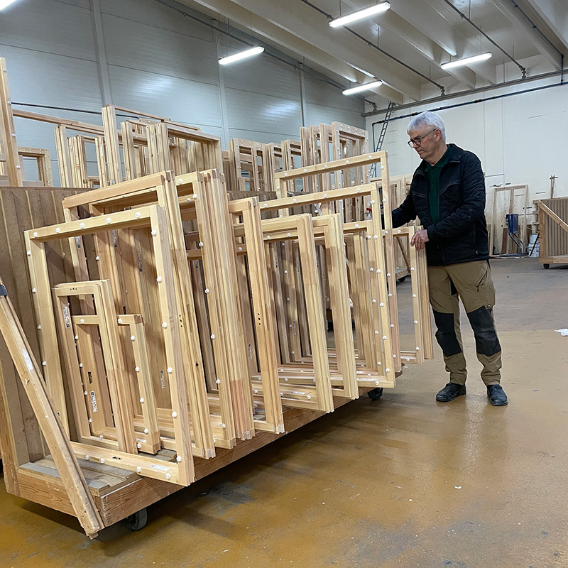 Finn Jepsen der står  ved nogle vinduesrammer.