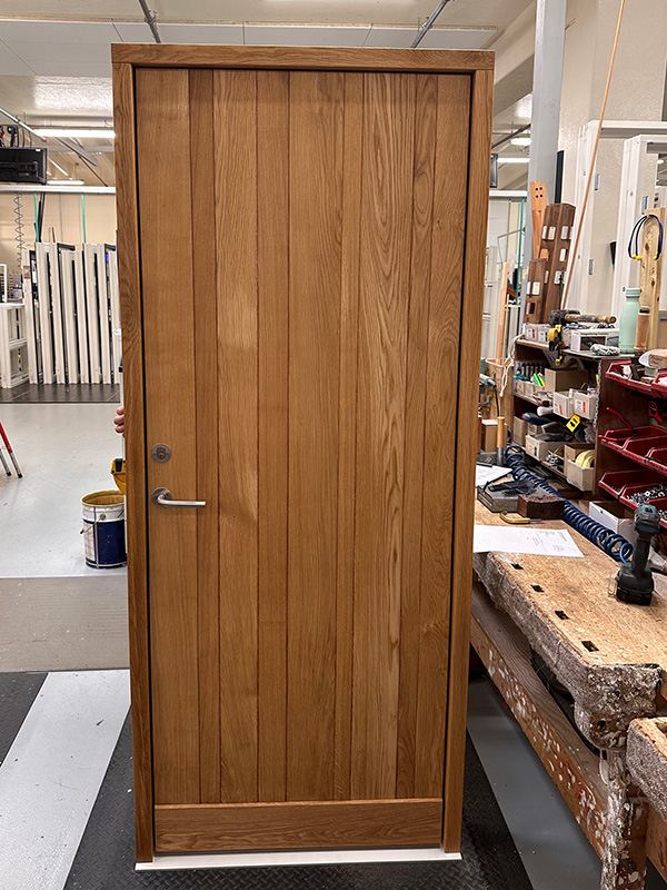 Pladedør beklædt med lister i egetræ.