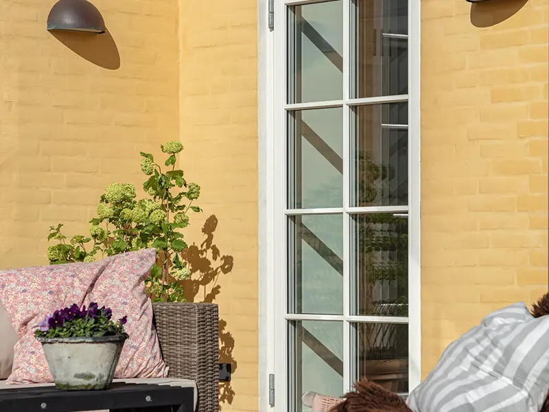 en Terrasse med en terrassedør med bondehus sprosser og i farven hvid