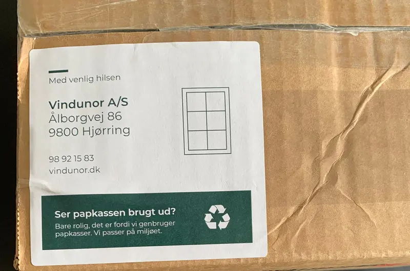 Et klistermærke som sættes på papkasser, hvor vi skriver - ser papkassen brugt ud? Vi genbruger papkasser.