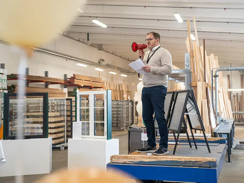 Åben Fabrik 2024 - Henrik holder tale i en rød megafon.