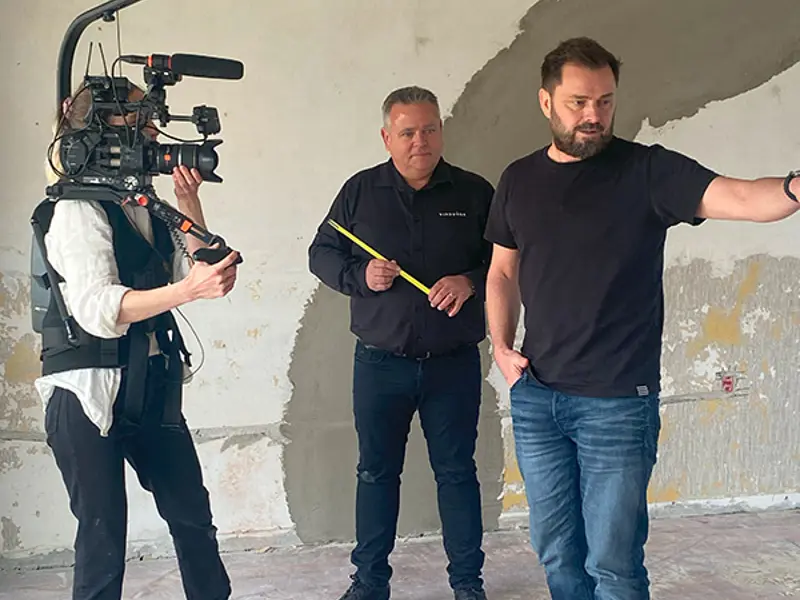 Boligkøb i blinde filmes og Jes er med for at komme med vejledning. Arkitekten peger for at vise hvad han havde tænkt.