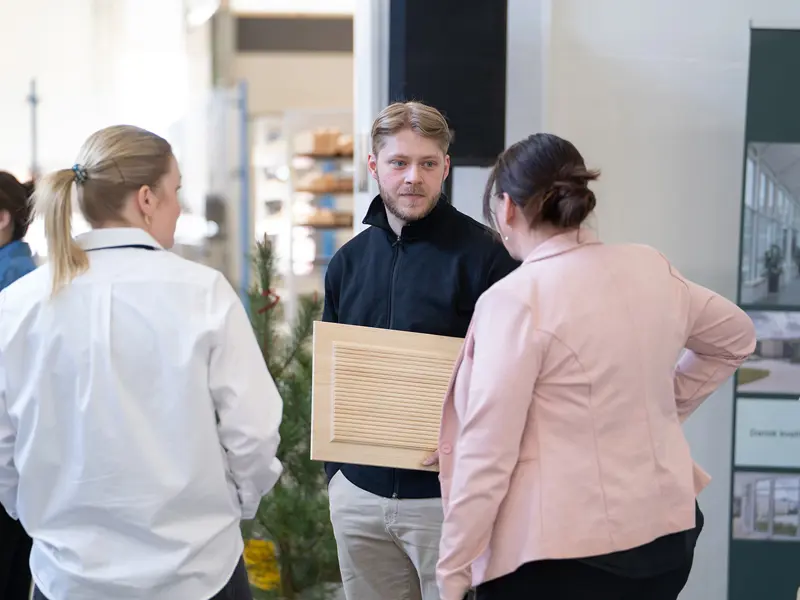 Åben Fabrik 2025 - en mand står med et produkt og taler med to om hvad der sker.