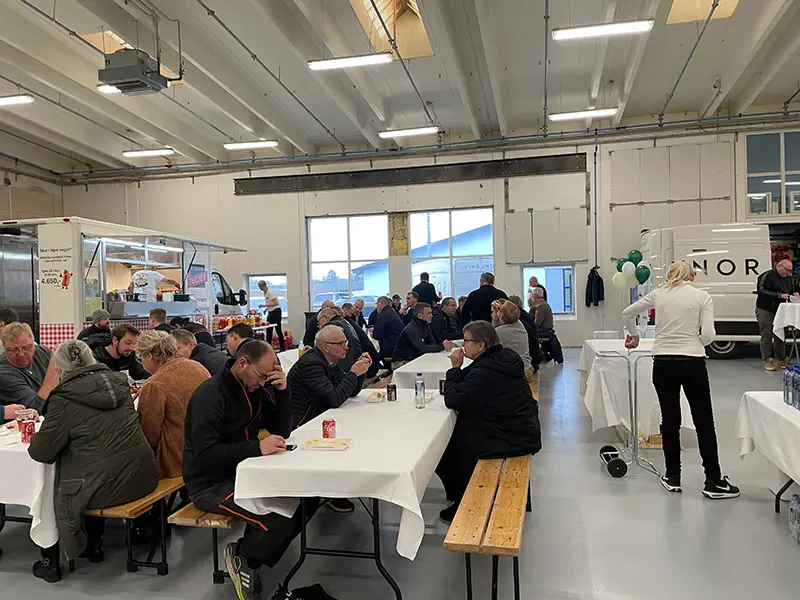 Åben Fabrik 2023 - Gæster sidder ved bordene og spiser hotdogs.
