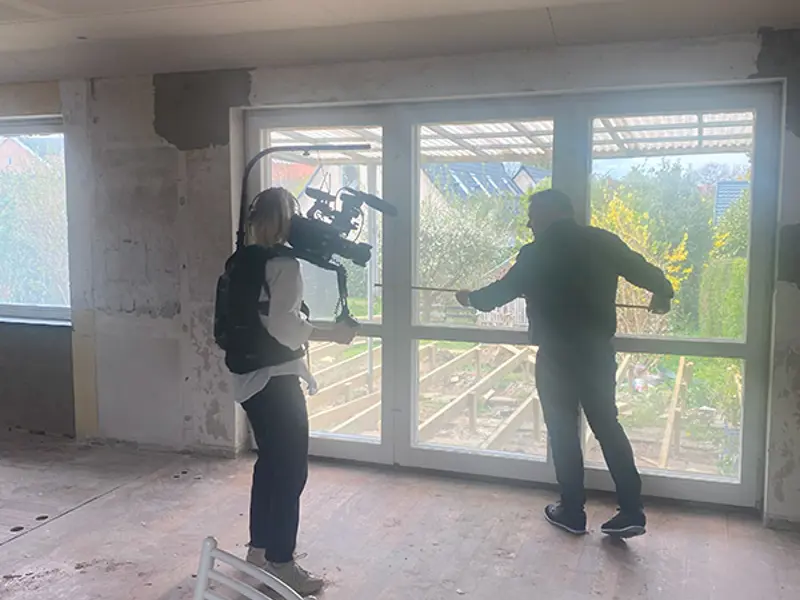 Boligkøb i blinde filmes og Jes måler op til breden på den nye skydedør.