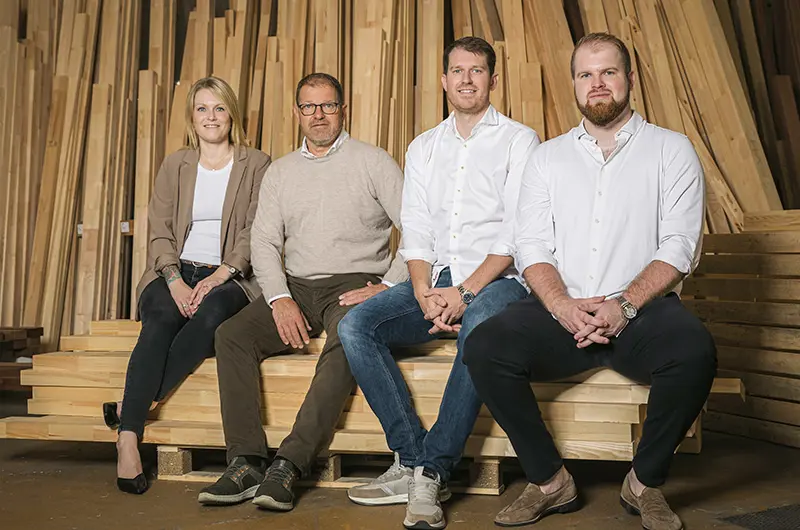 Caroline, Mikkel, Casper og Henrik sidder på palle med stabler af pinde.